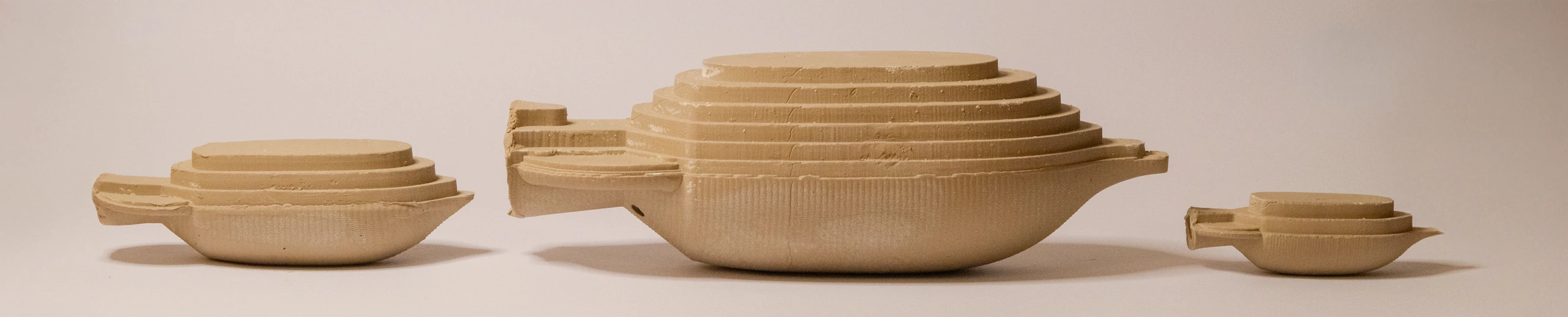 Three clay Amphora forms at different scales, with stepped faces above finely textured curved sides